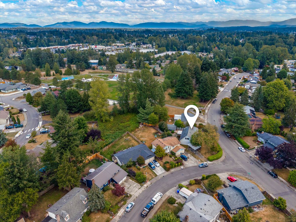 Aerial view of the neighborhood looking toward distant mountains, with the home marked by a location pin