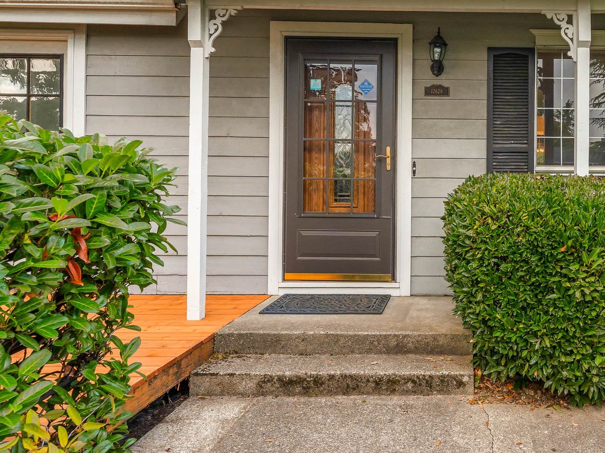 Close view of the front door and the newly built cedar deck beside the entry steps